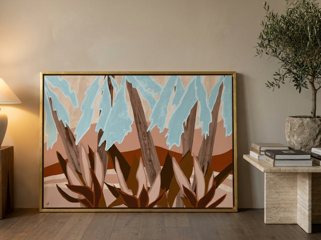 Canvas wall art with a gold leaf surround leaning against the wall in a luxe home office