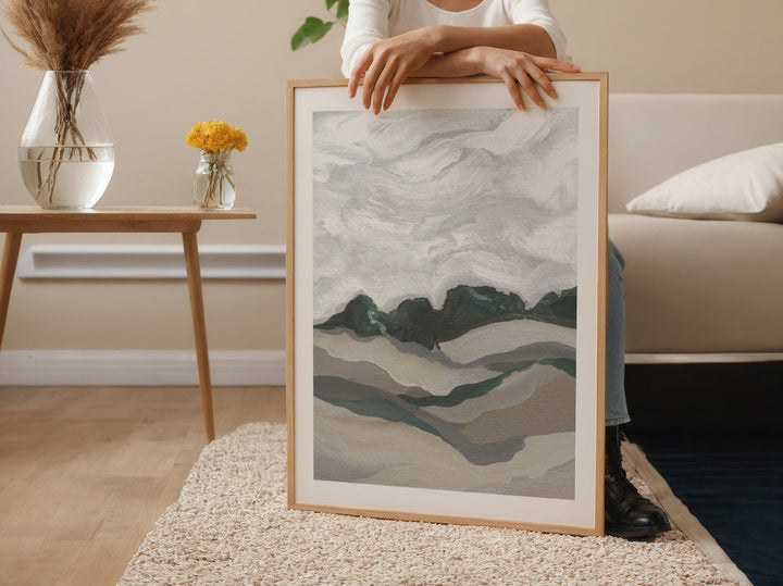 Person holding an abstract art piece in a living room.