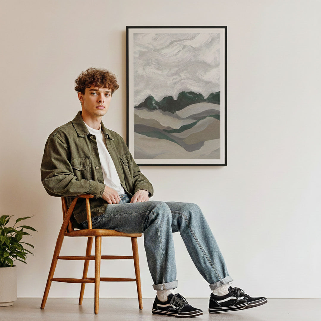 Man sitting on a wooden stool in a room with an abstract painting on the wall.
