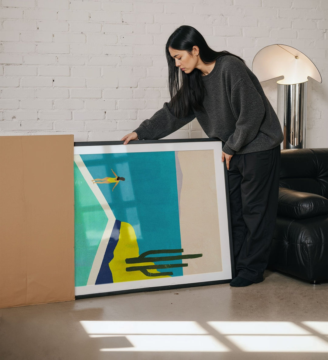 Woman holding an abstract artwork in a living room.