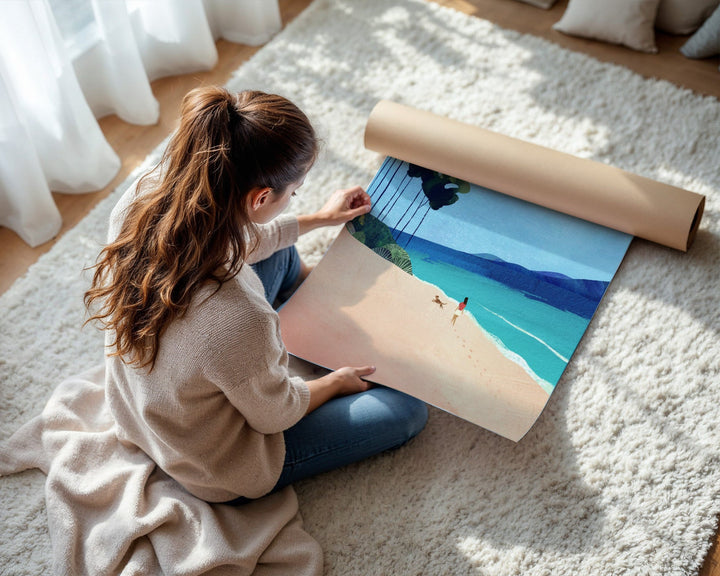 Woman unrolling a large beach scene print on a carpeted floor.