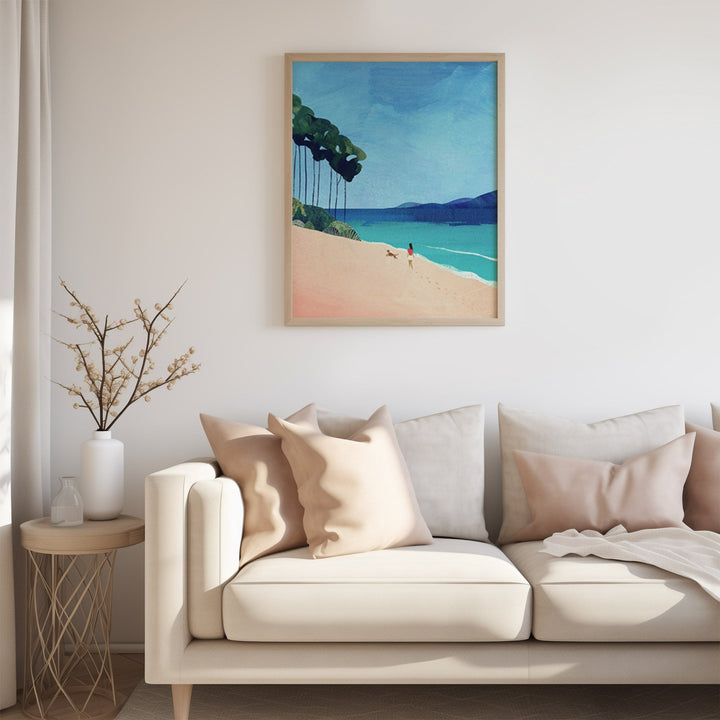 Beige sofa with decorative pillows in a living room setting, featuring a  beach painting on the wall.