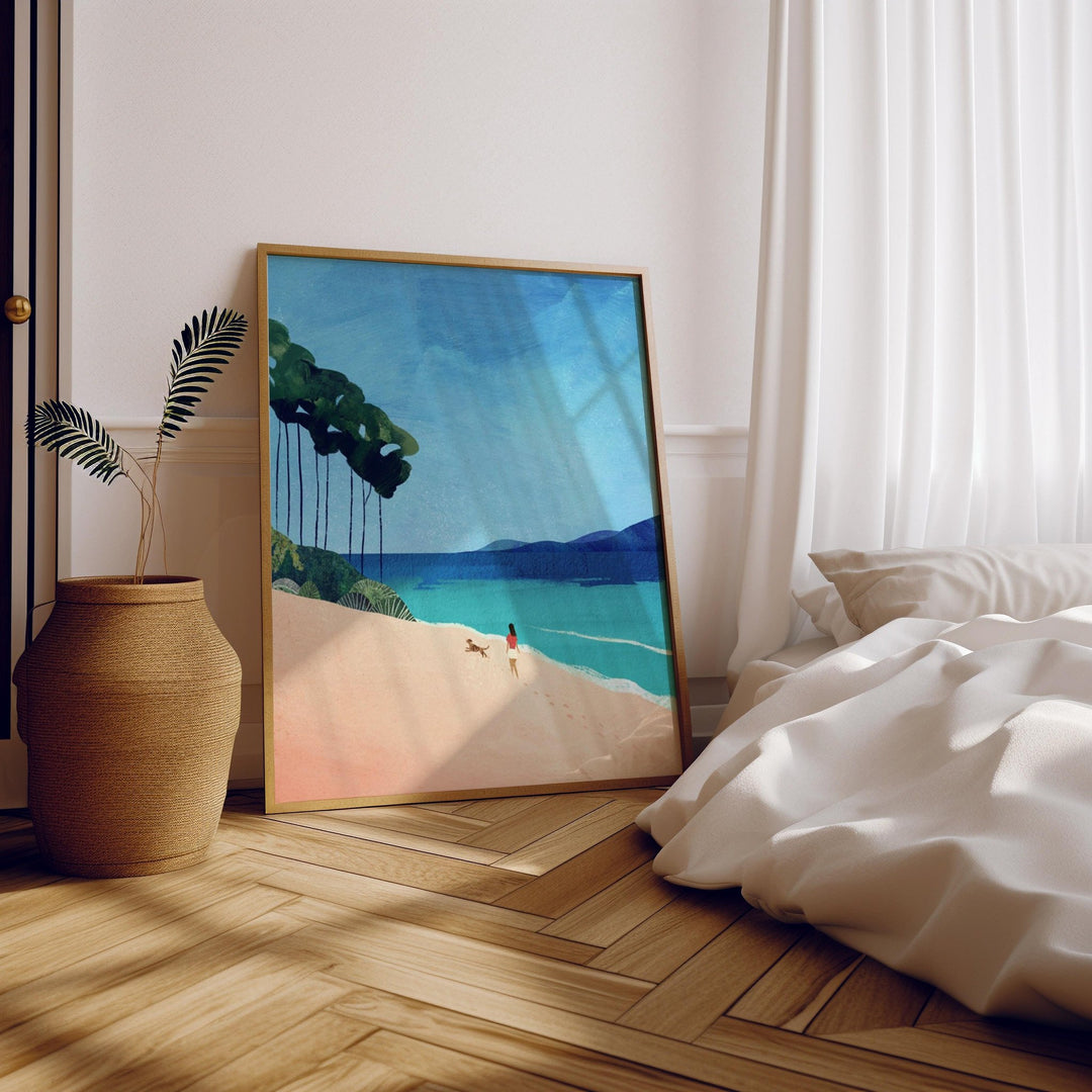 Beach painting on a wall above a bed with wooden floor and plant.