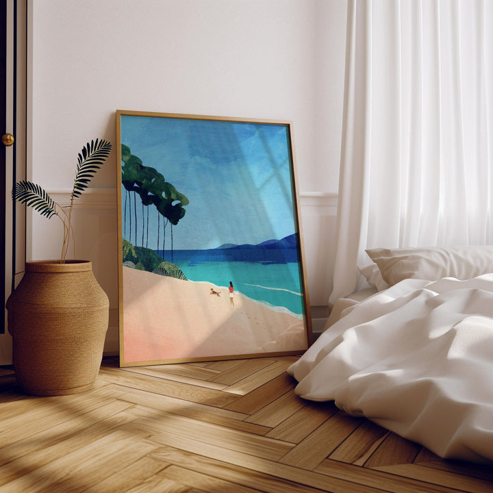 Beach painting on a wall above a bed with wooden floor and plant.