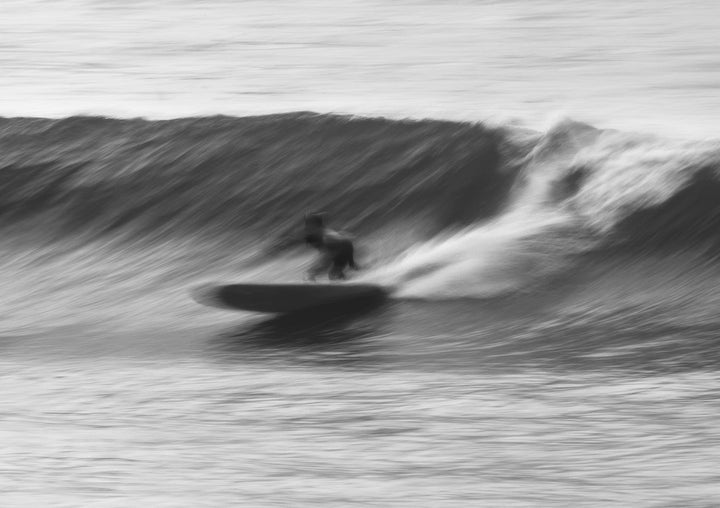 Black and white photo of a surfer riding a wave framed