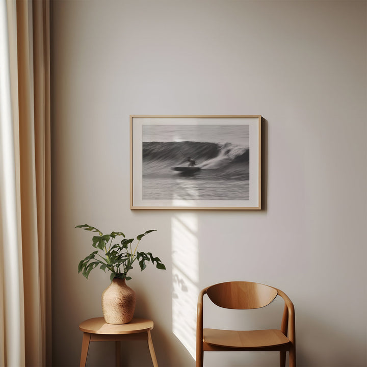 artwork on a wall with a plant and wooden chair below
