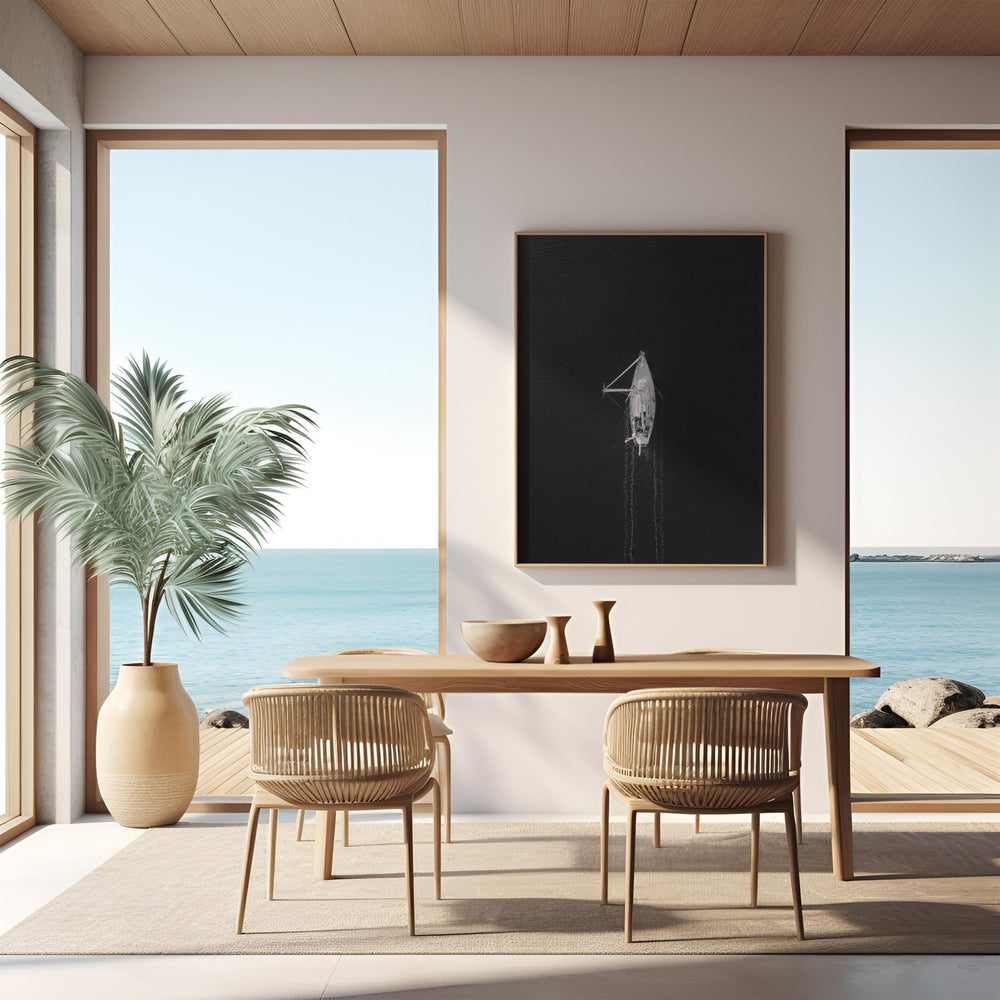 Modern dining room with ocean view through large windows, wooden table, and chairs.