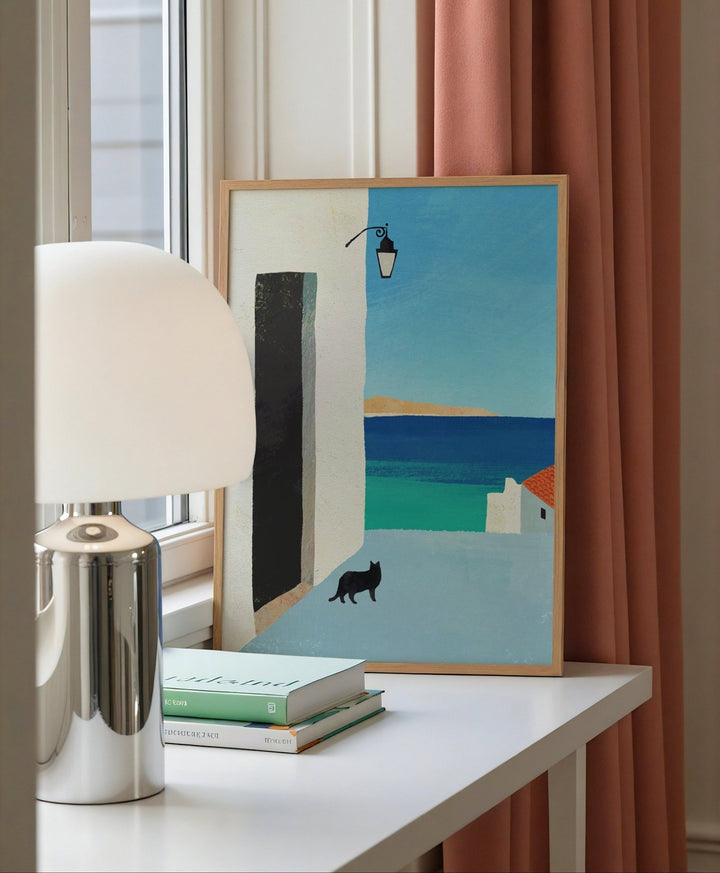 Artwork on a table with a lamp and books, next to a window with pink curtains.