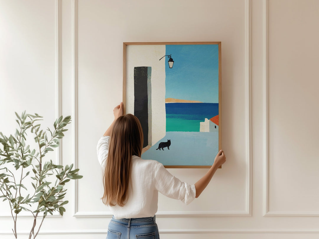 Person hanging a colorful abstract painting on a wall