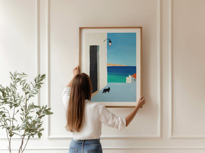 Person hanging an abstract art piece on a wall