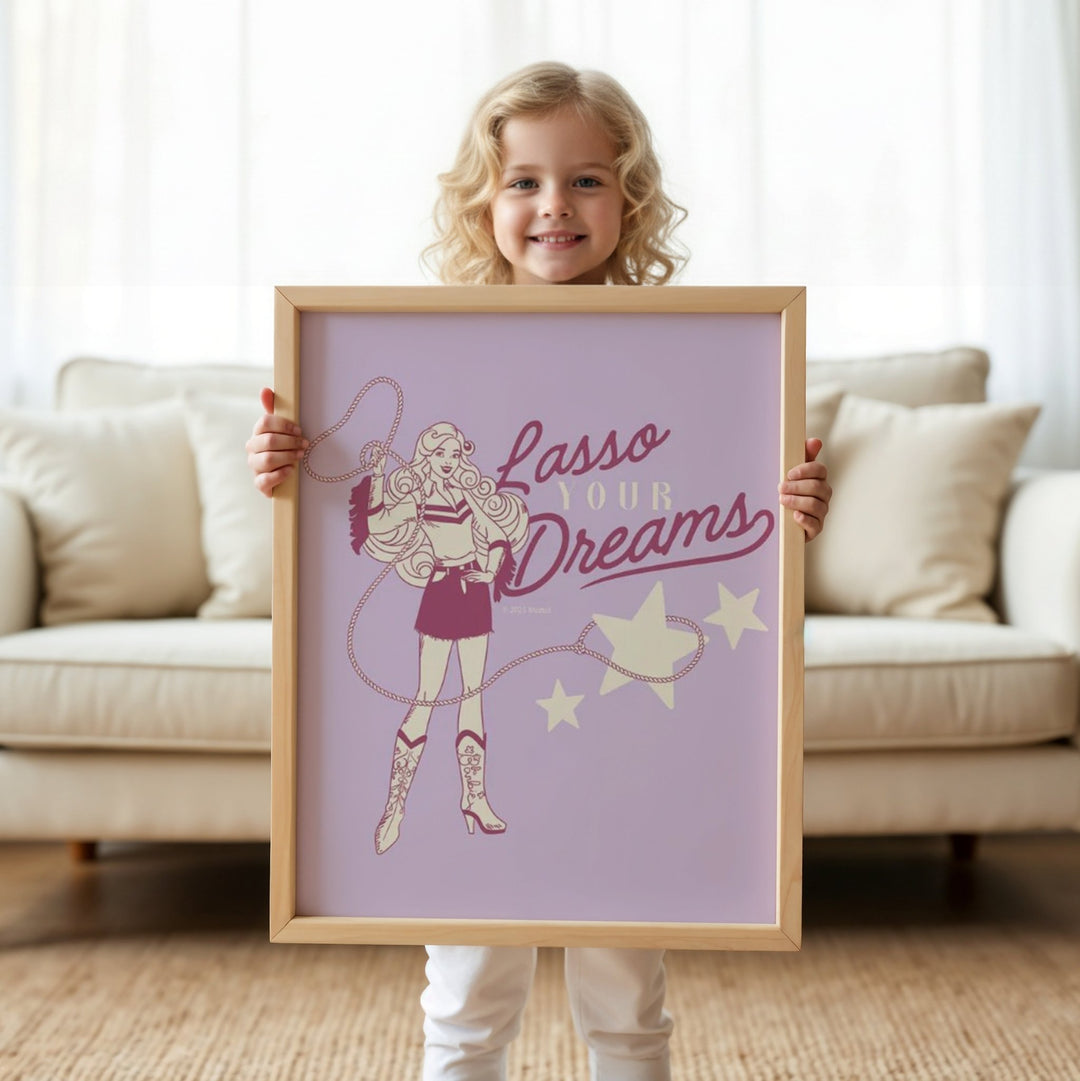 Child holding a picture with 'Lasso Your Dreams' text in a living room.