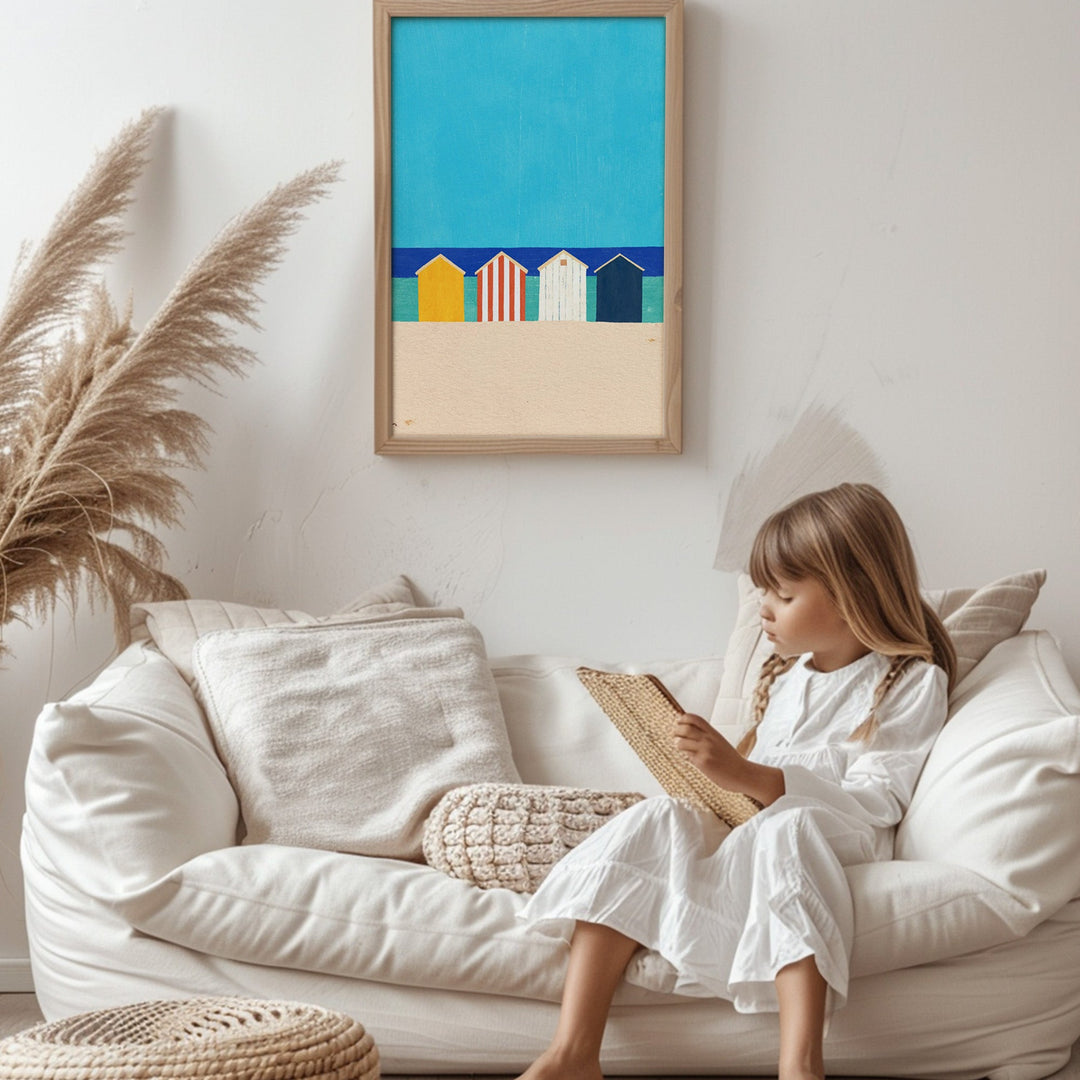 Child reading a book on a white couch with a colorful beach scene painting above.