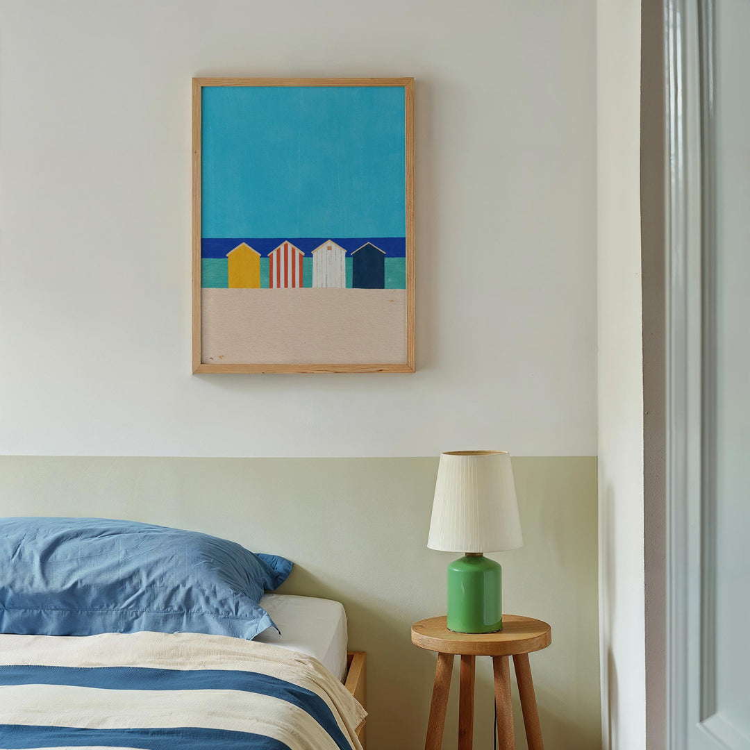 Bedroom with a colorful abstract painting above a bed, a green lamp on a wooden side table.