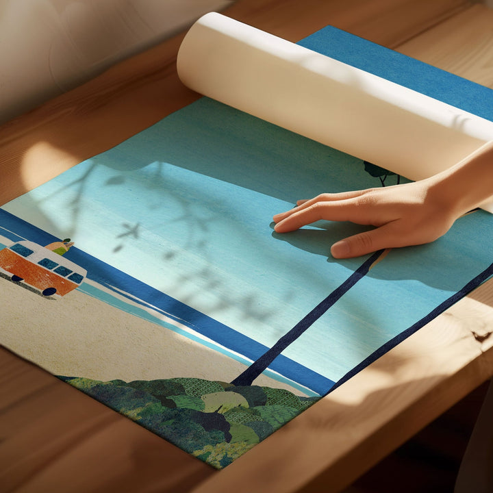 Person rolling out a colorful placemat with a scenic design on a wooden surface
