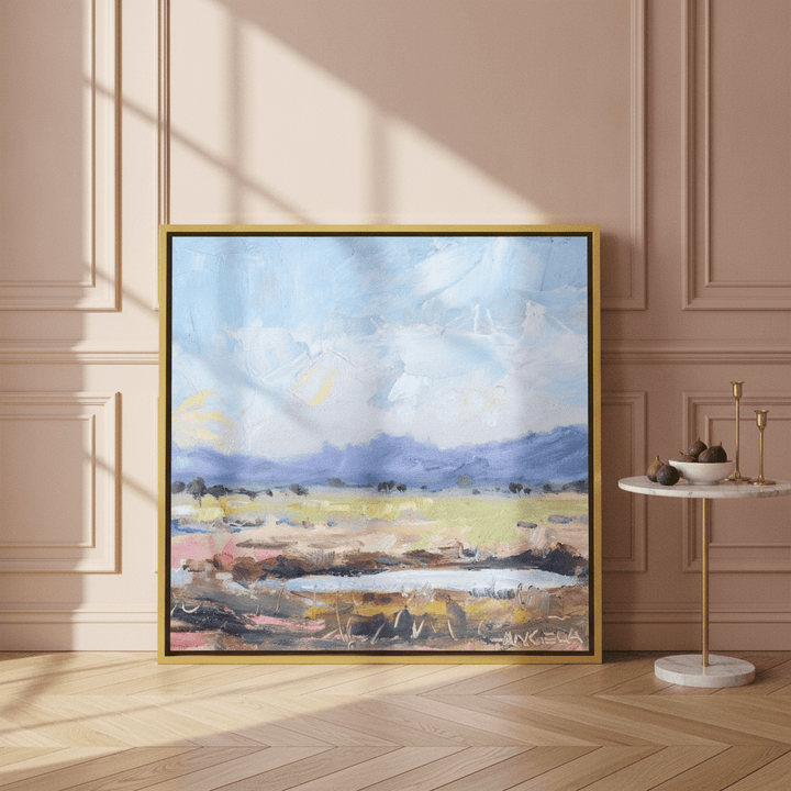 Canvas wall art with a gold leaf surround leaning against the wall in a Parisian living room