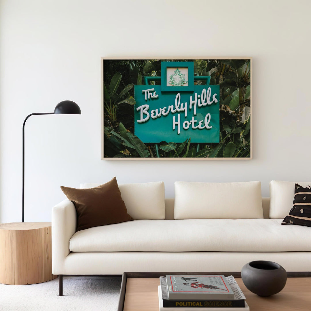 Living room with a picture of 'The Beverly Hills Hotel' above a white sofa.