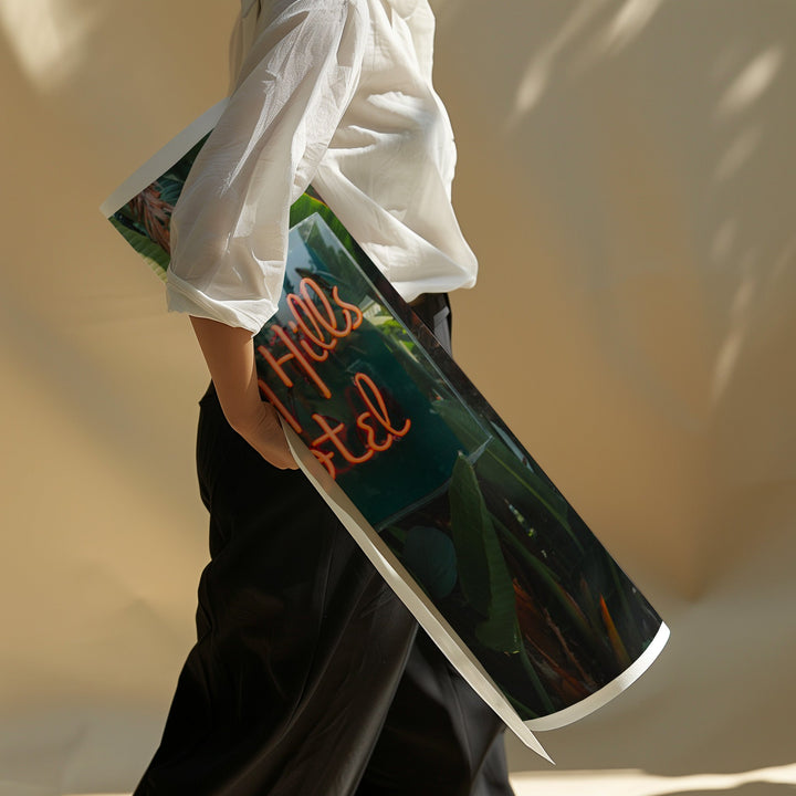 Person holding a magazine with a visible title against a neutral background