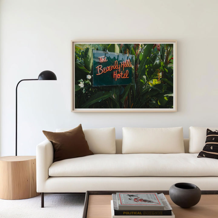 Living room with a picture of The Beverly Hills Hotel on the wall above a beige sofa.