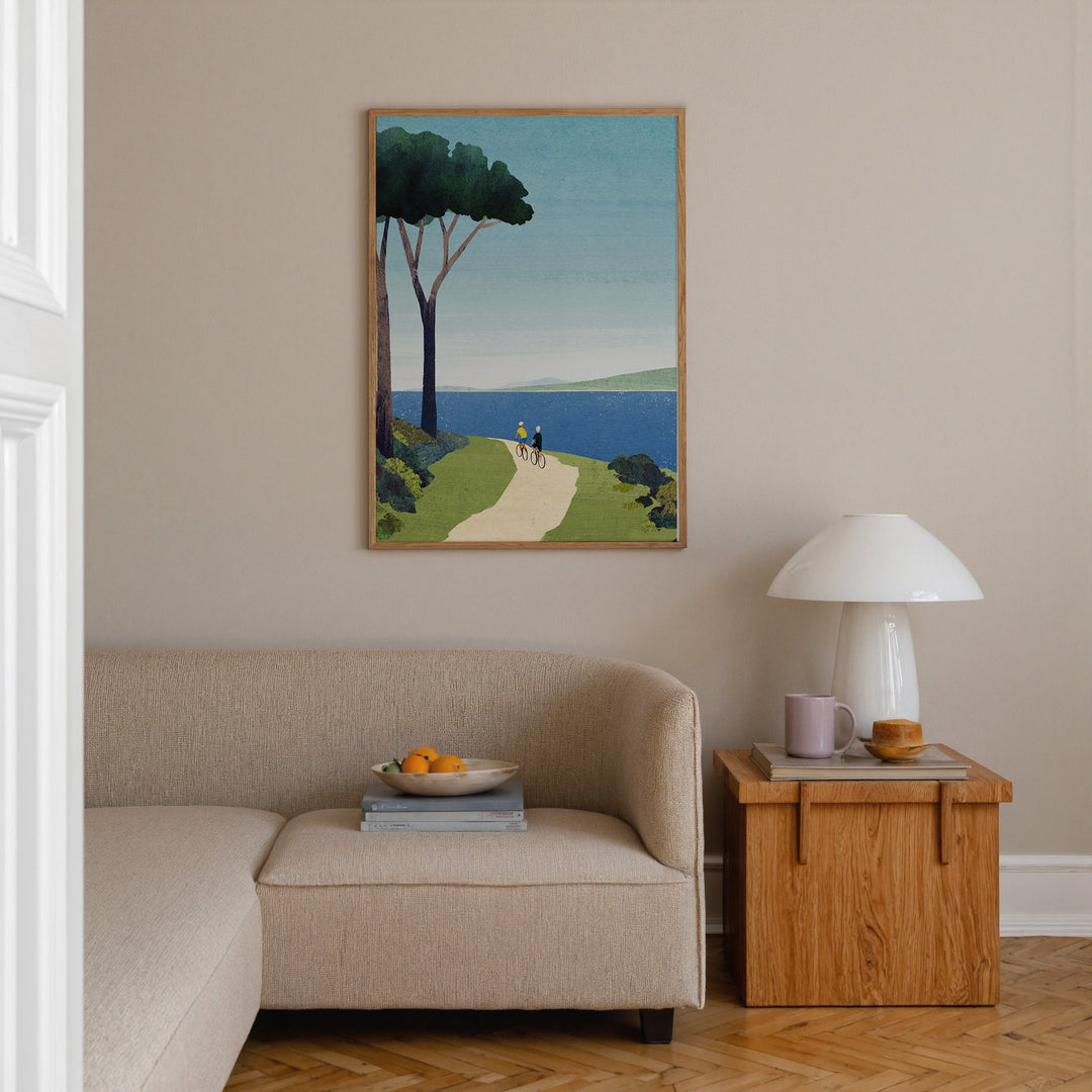 Living room with a beige sofa, wooden side table, and a painting of a landscape on the wall.