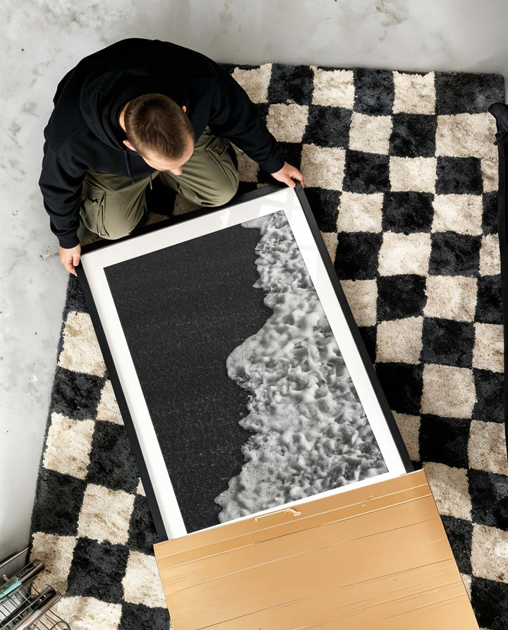 Person holding a black and white photo on a checkered rug