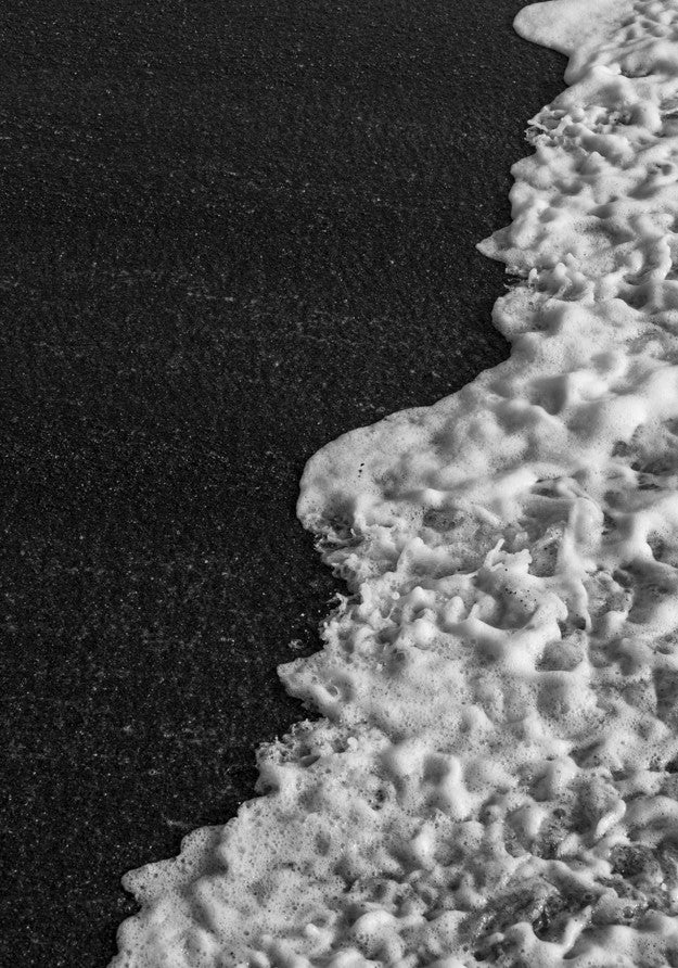 Close-up of a textured white surface against a black background, framed