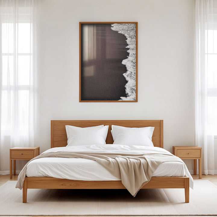 Wooden bed with white bedding in a minimalistic bedroom setting.