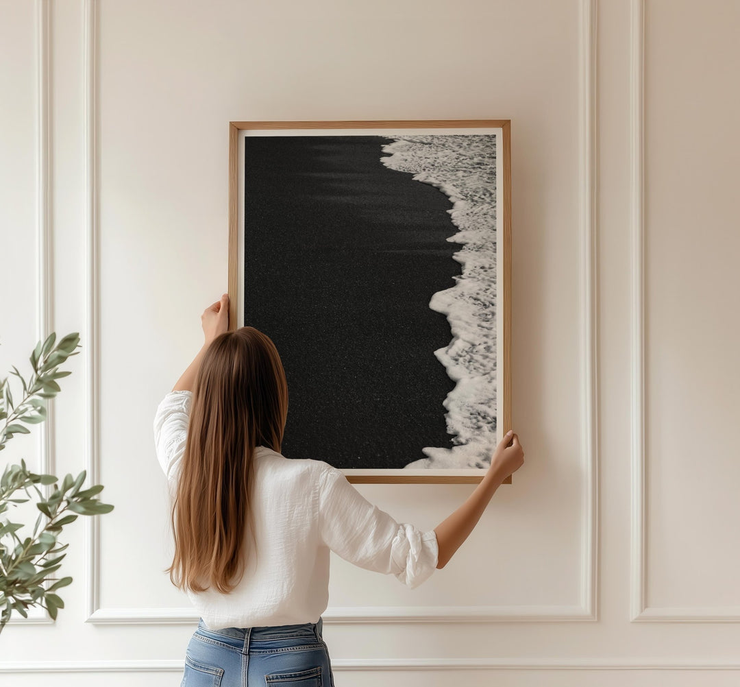 Person hanging an artwork on a wall