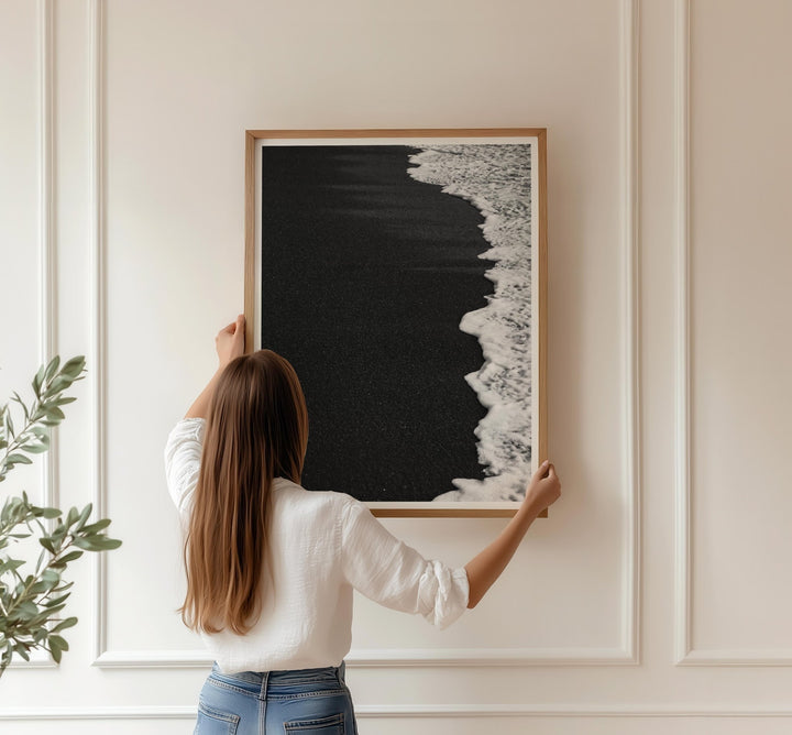 Person hanging an artwork on a wall