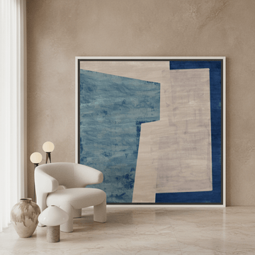 Oversized statement canvas wall art with a white surround leaning against the wall in a luxe dining room