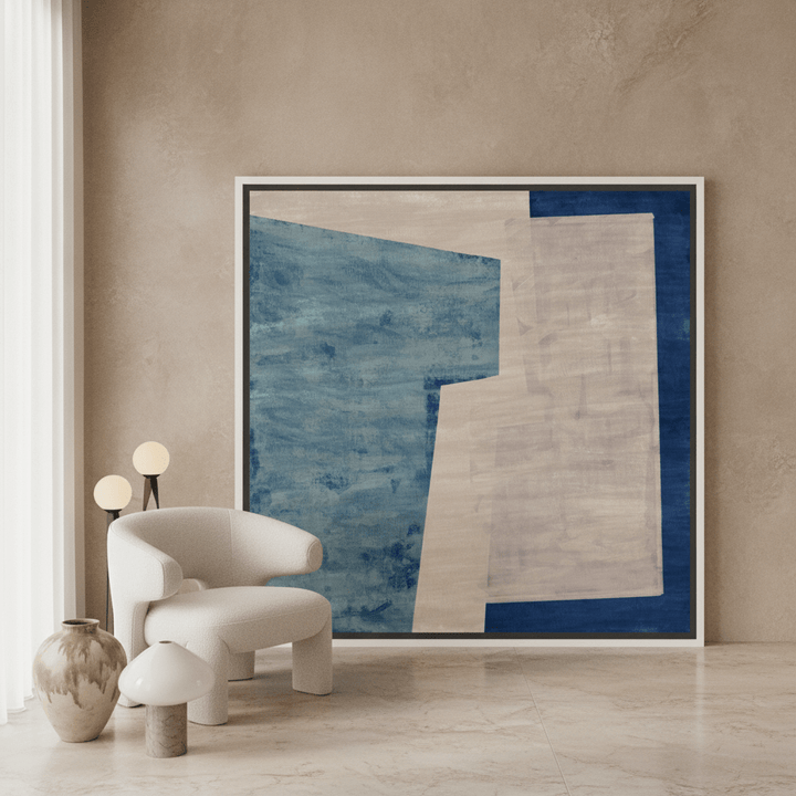 Oversized statement canvas wall art with a white surround leaning against the wall in a luxe dining room