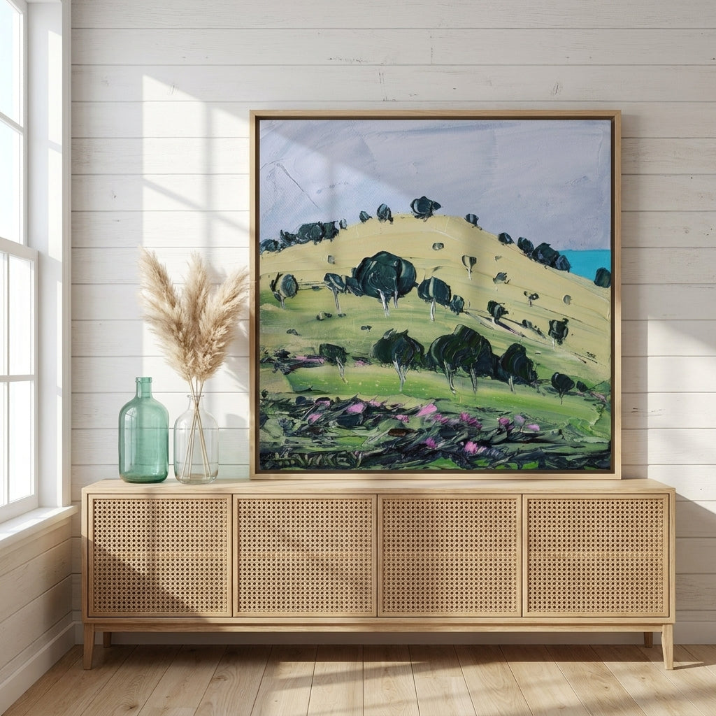Canvas wall art with a natural timber surround standing on a sideboard in a coastal bedroom
