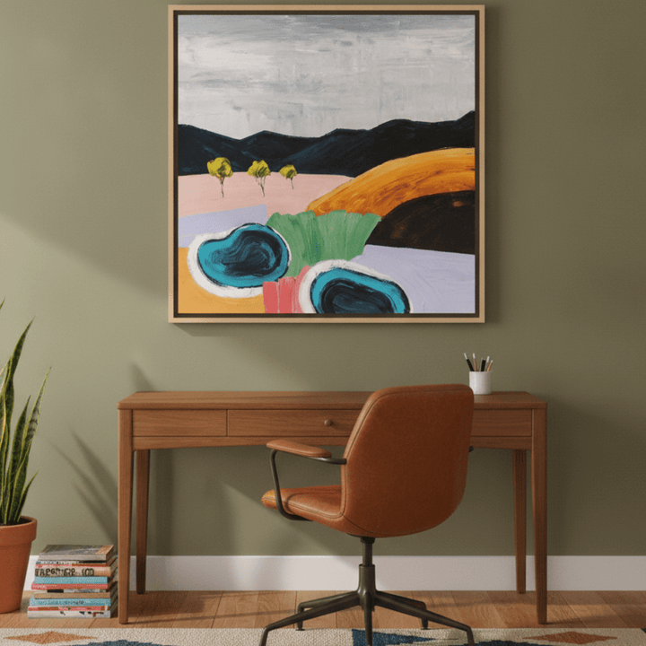 Canvas wall art with a natural timber surround styled on the wall in a mid-century home office