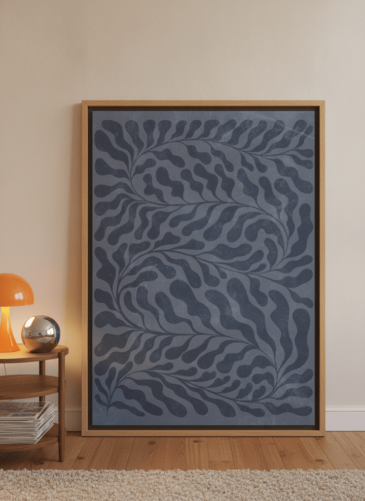 Oversized statement canvas wall art with a natural timber surround leaning against the wall in a retro 70s bedroom