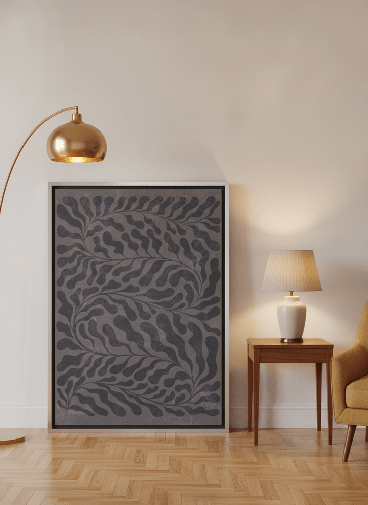 Canvas wall art with a silver leaf surround leaning against the wall in a mid-century home office