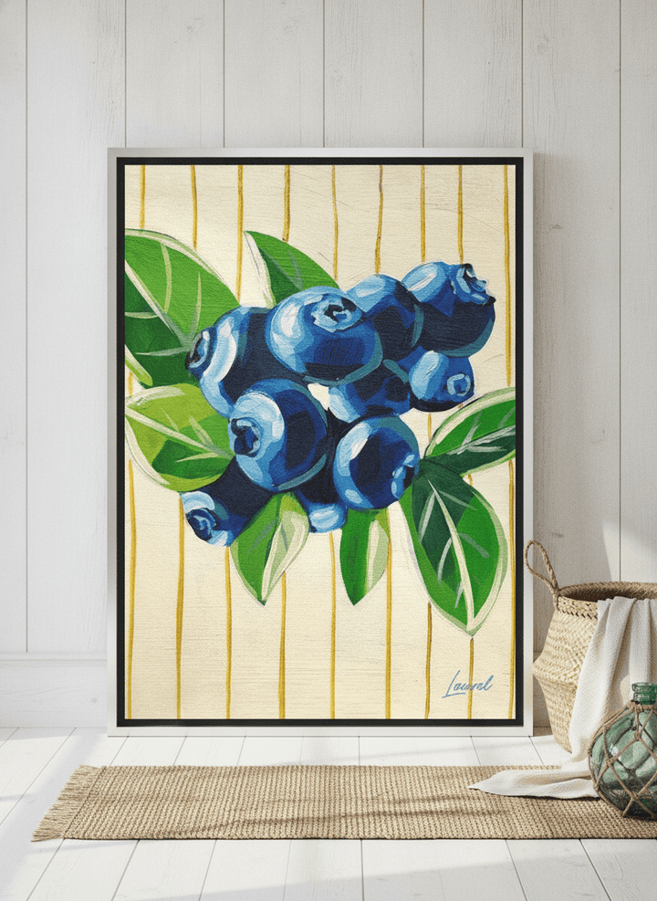 Canvas wall art with a silver leaf surround leaning against the wall in a coastal bathroom