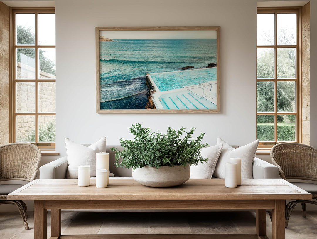 Living room with a wooden coffee table, potted plant, and  artwork of a pool.