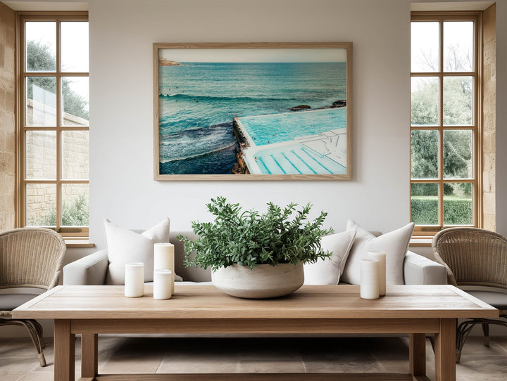 Living room with a wooden coffee table, potted plant, and  artwork of a pool.