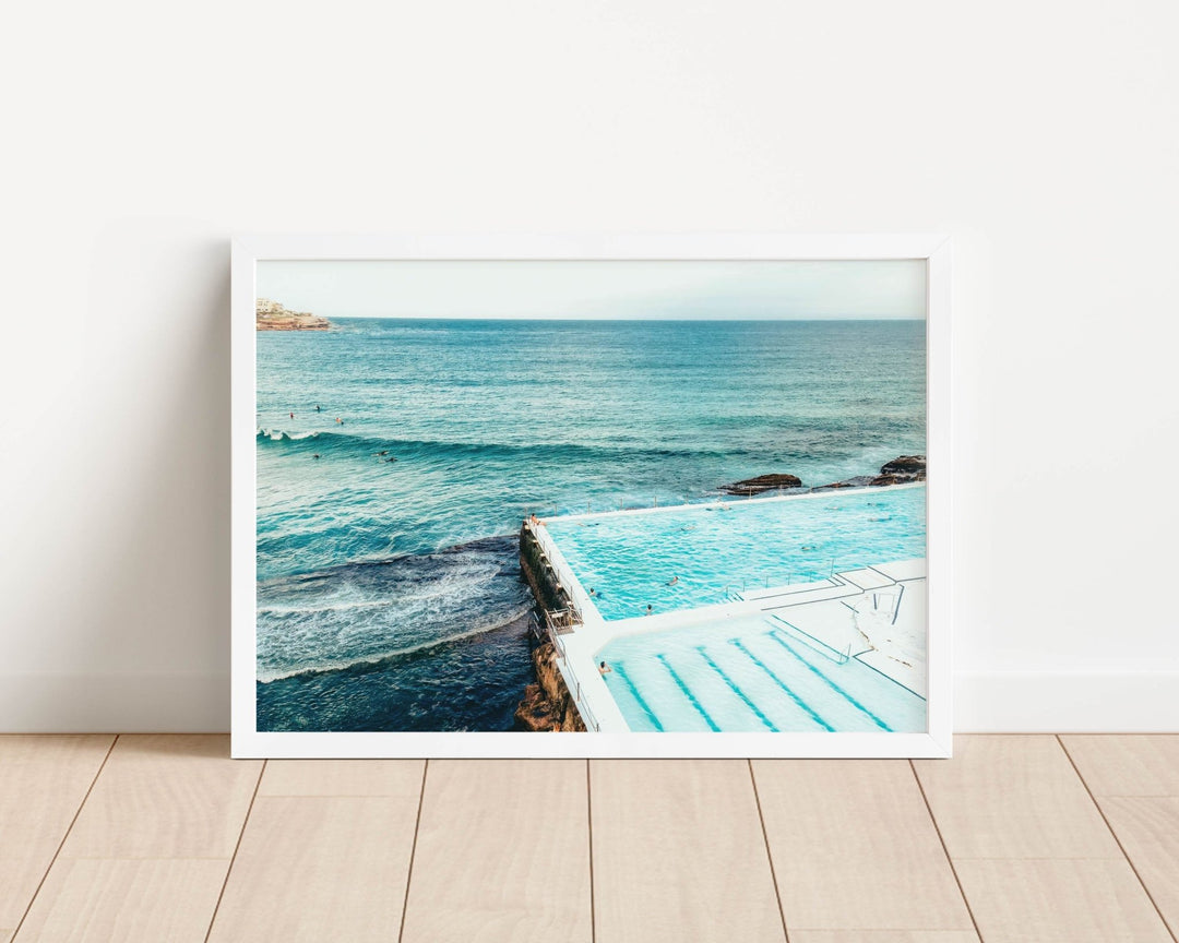 photograph of a pool with ocean view on a wooden floor.