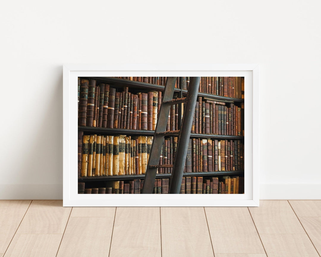 picture of a ladder against a wall of old books on a wooden floor.