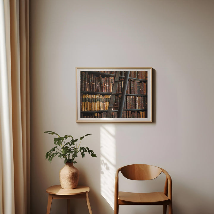 Artwork on a wall with a plant and chair below