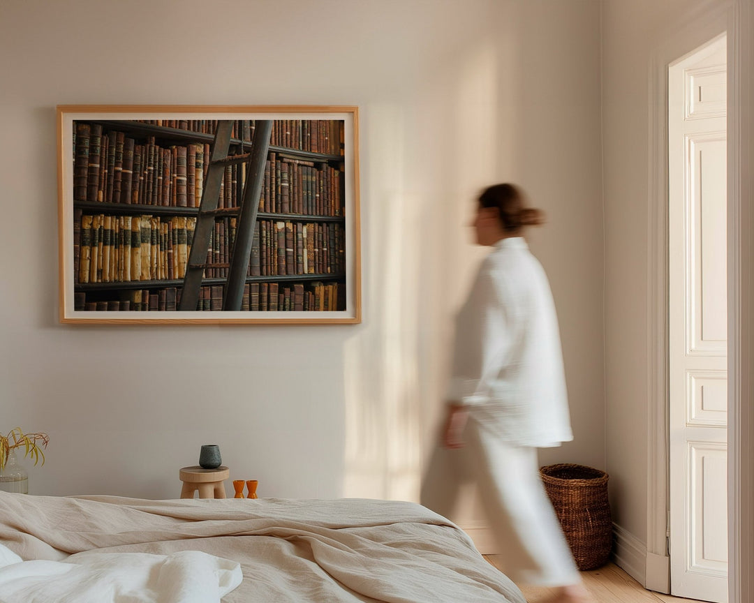 Woman walking in a bedroom with a large picture on the wall.