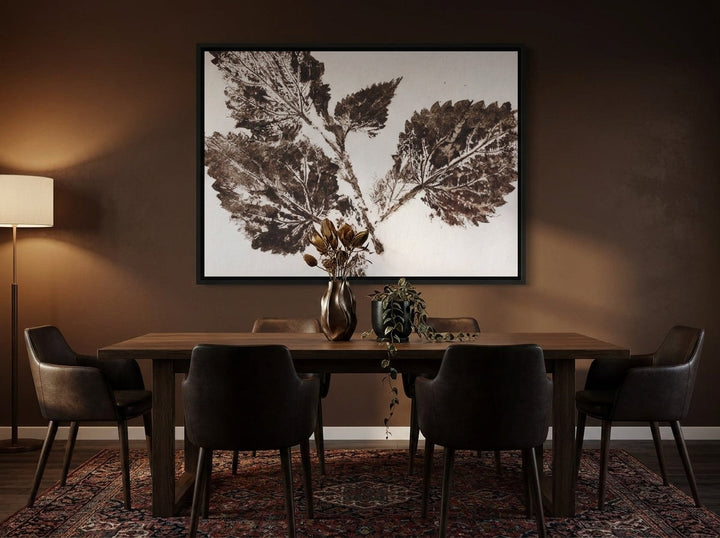 Oversized statement canvas wall art with a black surround styled on the wall in a moody dining room