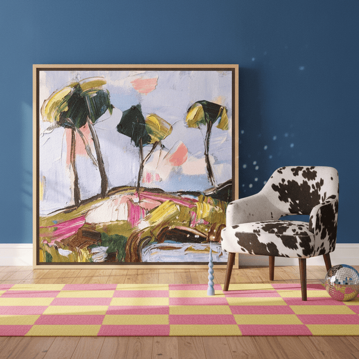 Oversized statement canvas wall art with a natural timber surround leaning against the wall in a colourful eclectic dining room