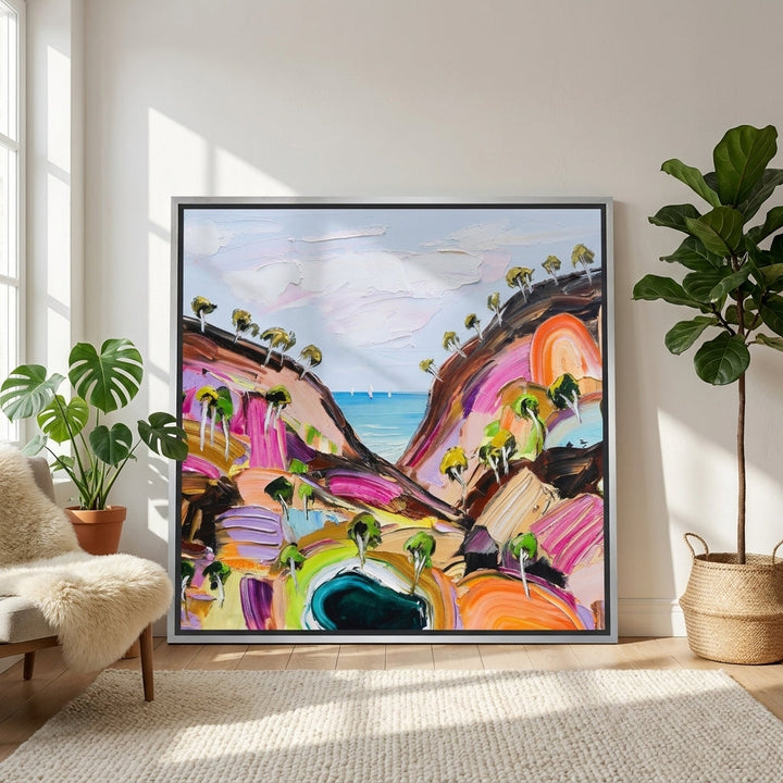 Oversized statement canvas wall art with a silver leaf surround leaning against the wall in a bright Scandinavian living room