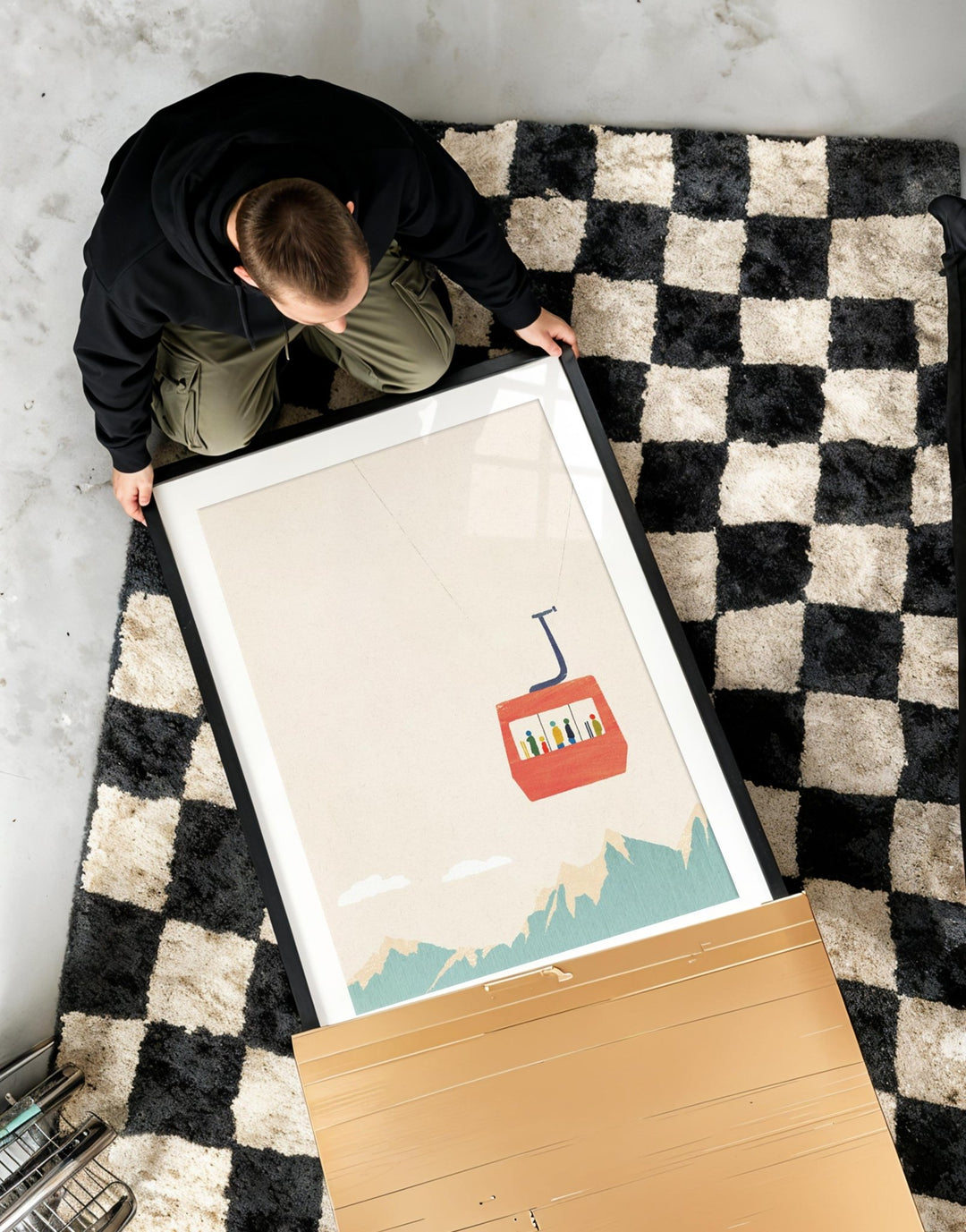 Person unboxing an artwork on a checkered rug