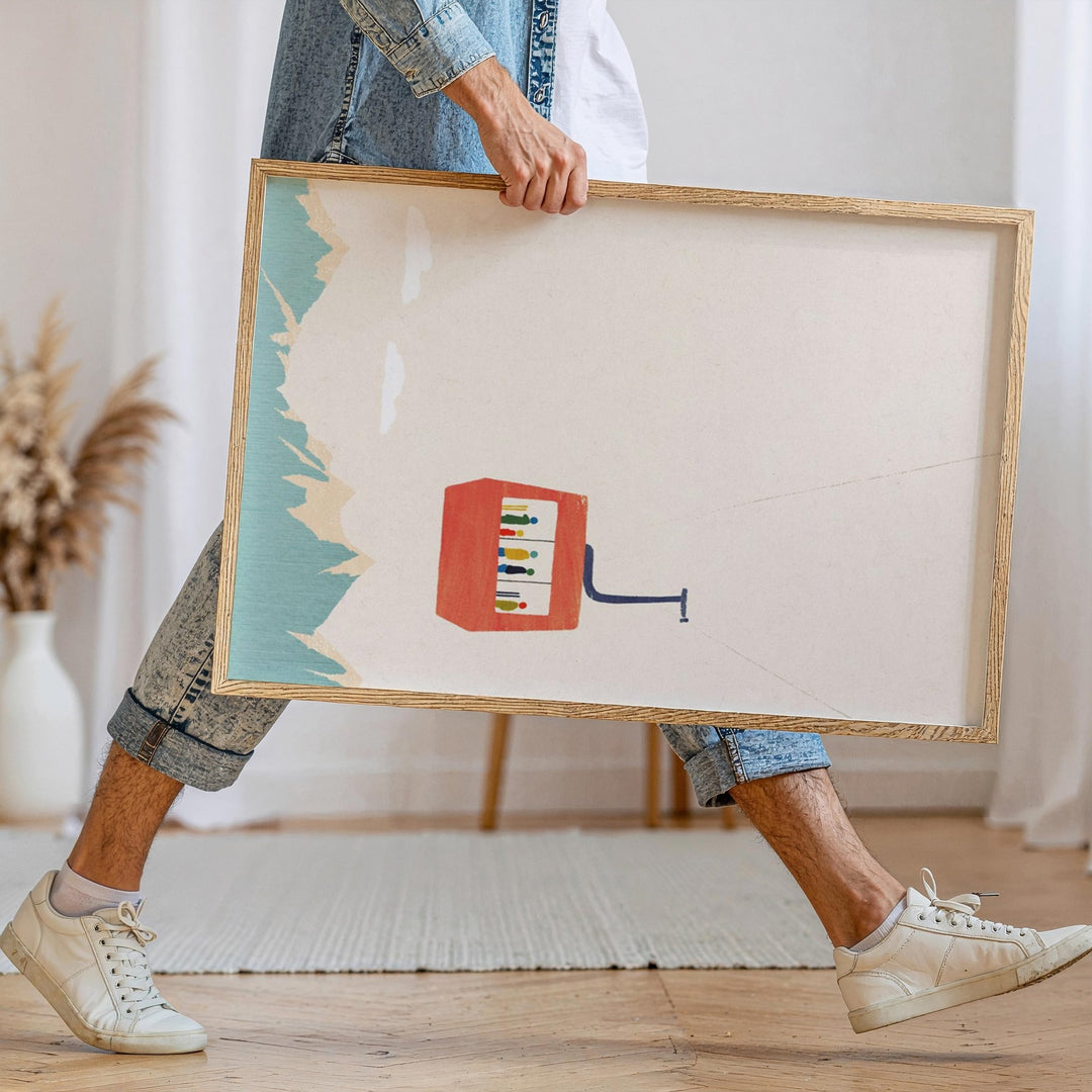 Person holding an artwork of a colorful abstract design in a home setting.