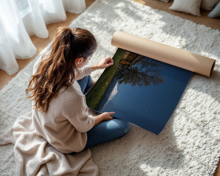 Woman unrolling a large piece of paper on a carpeted floor