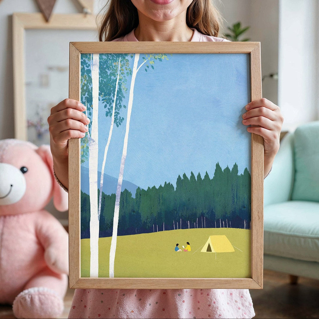 Woman holding an artwork of a forest scene with a tent and people, in a room with a pink teddy bear and light blue chair.