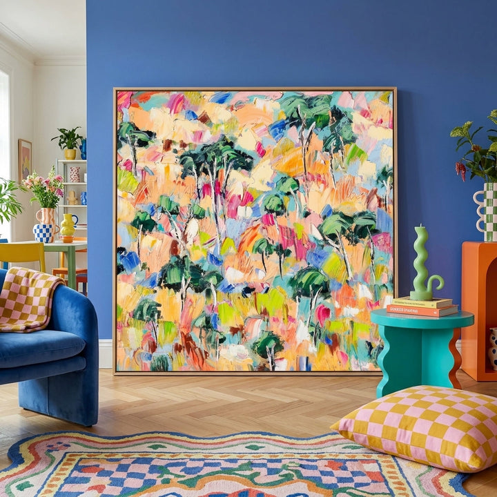 Oversized statement canvas wall art with a natural timber surround leaning against the wall in a colourful eclectic dining room