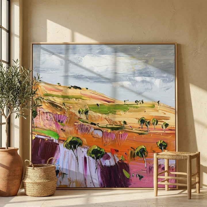 Oversized statement canvas wall art with a natural timber surround leaning against the wall in a Mediterranean dining room
